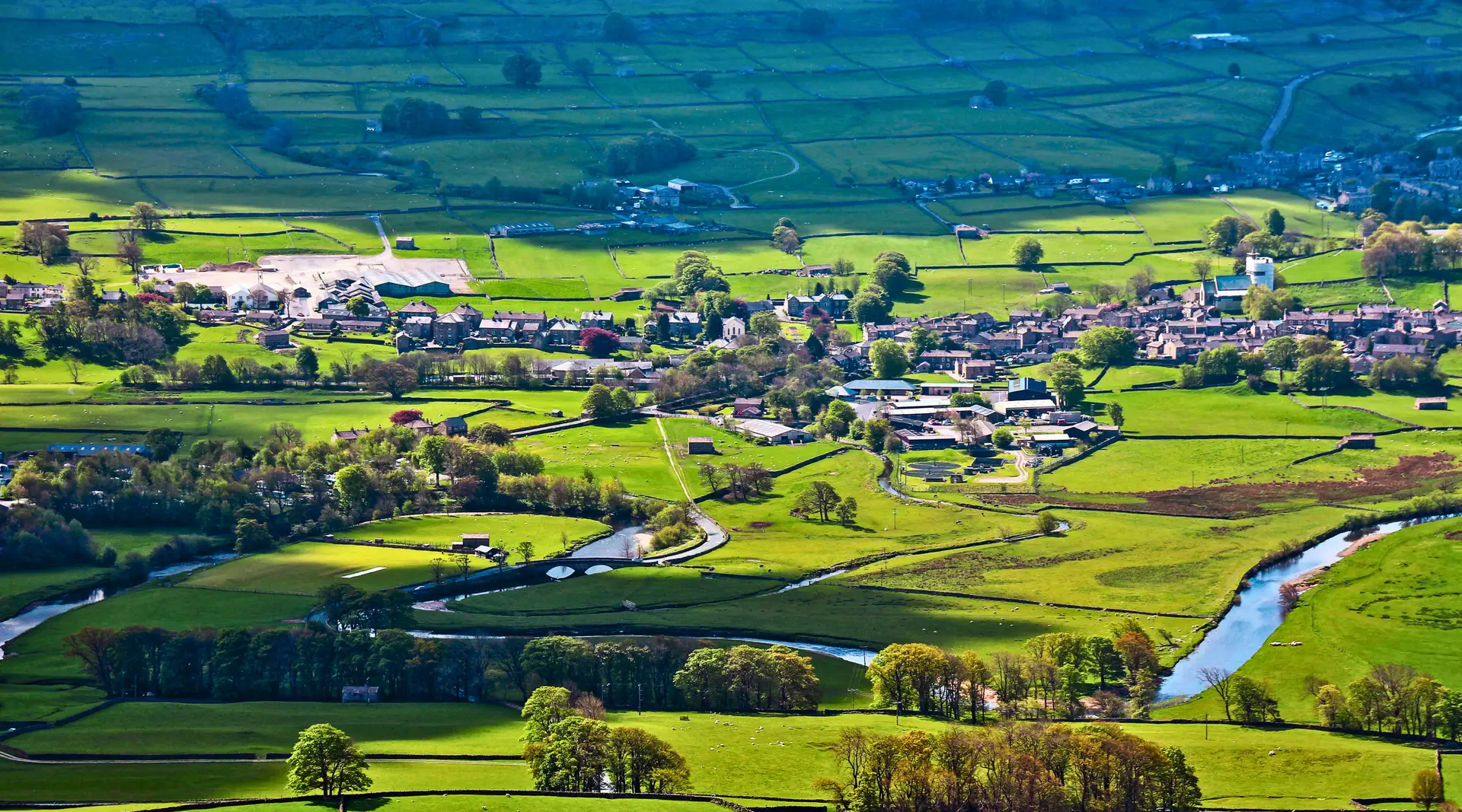 Green Yorkshire Dales countryside, village and winding river